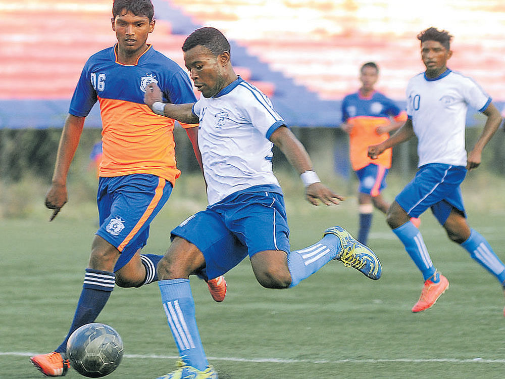 INTENSE Students Union FC's Emmanuel (right) attempts a shot as DYES defender Balagangadhar looks on. DH PHOTO