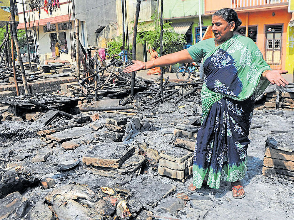 protest costs dear: A woman stands amid the wreckage of a burnt-out market after  clashes  between protesters and police during a demonstration against the ban on Jallikattu in Chennai on Tuesday. AFP