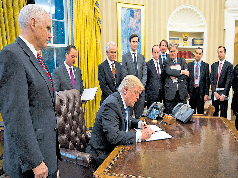 not pulling his punches: US President Donald Trump signs an executive order in the Oval Office of the White House in Washington, to formally abandon the Trans-Pacific Partnership, moving away from Asia and scrapping his predecessor's most significant trade deal. nyt