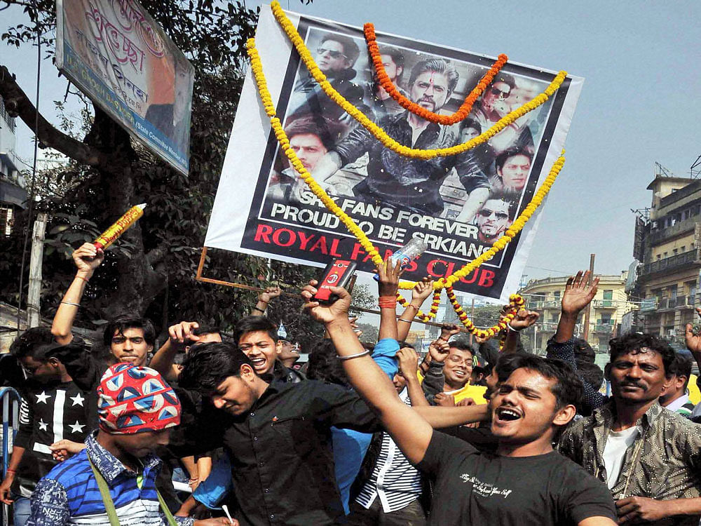 Fans of Bollywood actor Shah Rukh Khan celebrate the release of his movie 'Raees' near a cinema hall in Kolkata on Wednesday. PTI Photo