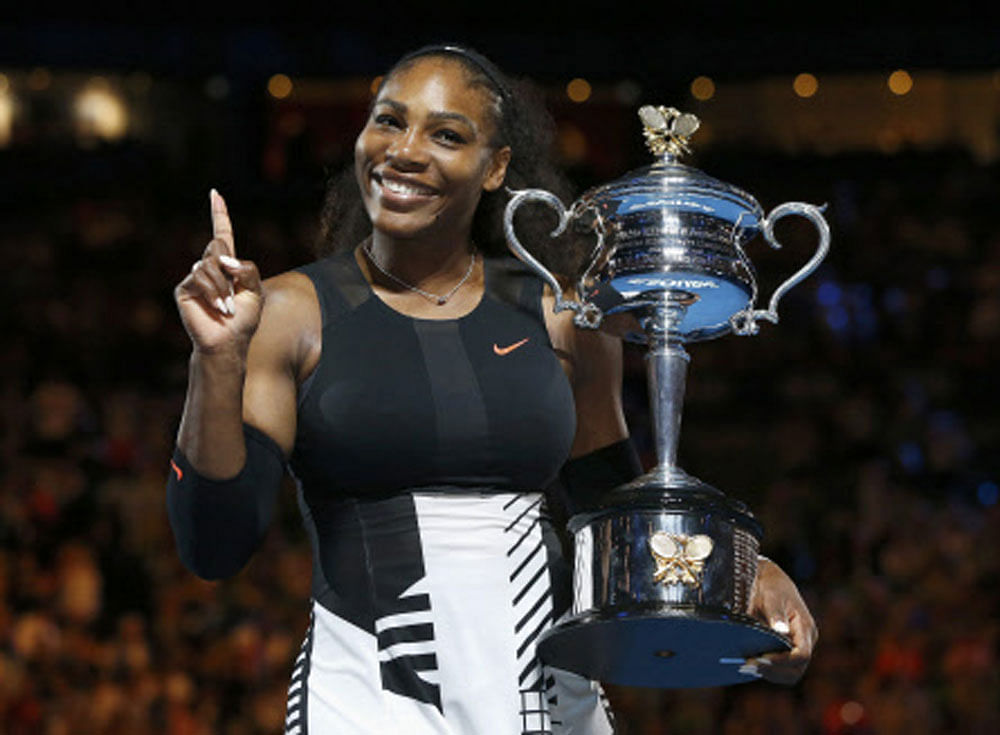 Serena Williams of the U.S. gestures while holding her trophy after winning her Women's singles final match against Venus Williams of the U.S. REUTERS