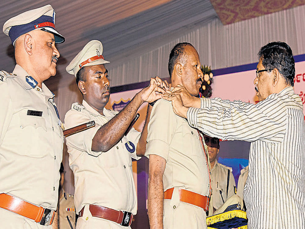 D N Hanumantharayappa, who got promoted as ASI, receives his badge from Home Minister G Parameshwara during the ranking ceremony at in Bengaluru on Monday. DH PHOTO