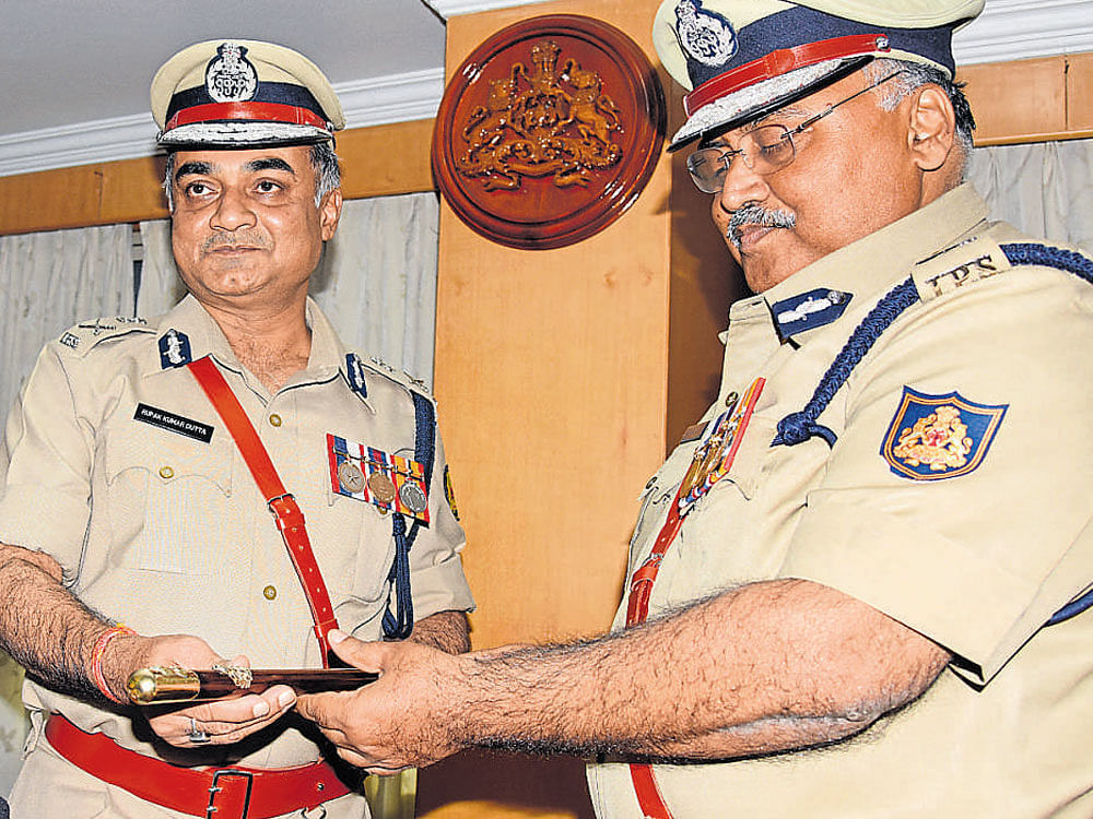 Newly appointed DG and IGP Rupak Kumar Dutta (left) takes charge from outgoing DG and IGP Om Prakash at the state  police head quarters in Bengaluru on Tuesday. dh Photo