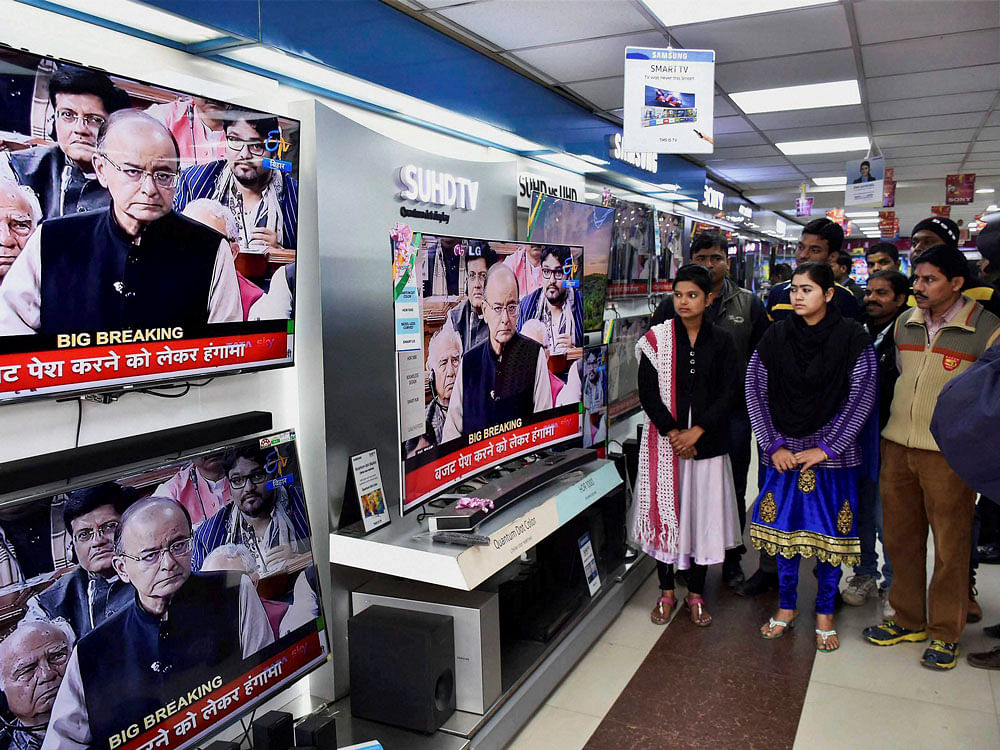 People watch Finance Minister Arun Jaitley tabling the Union Budget 2017-18, on TV sets at a showroom in Patna on Wednesday. PTI Photo