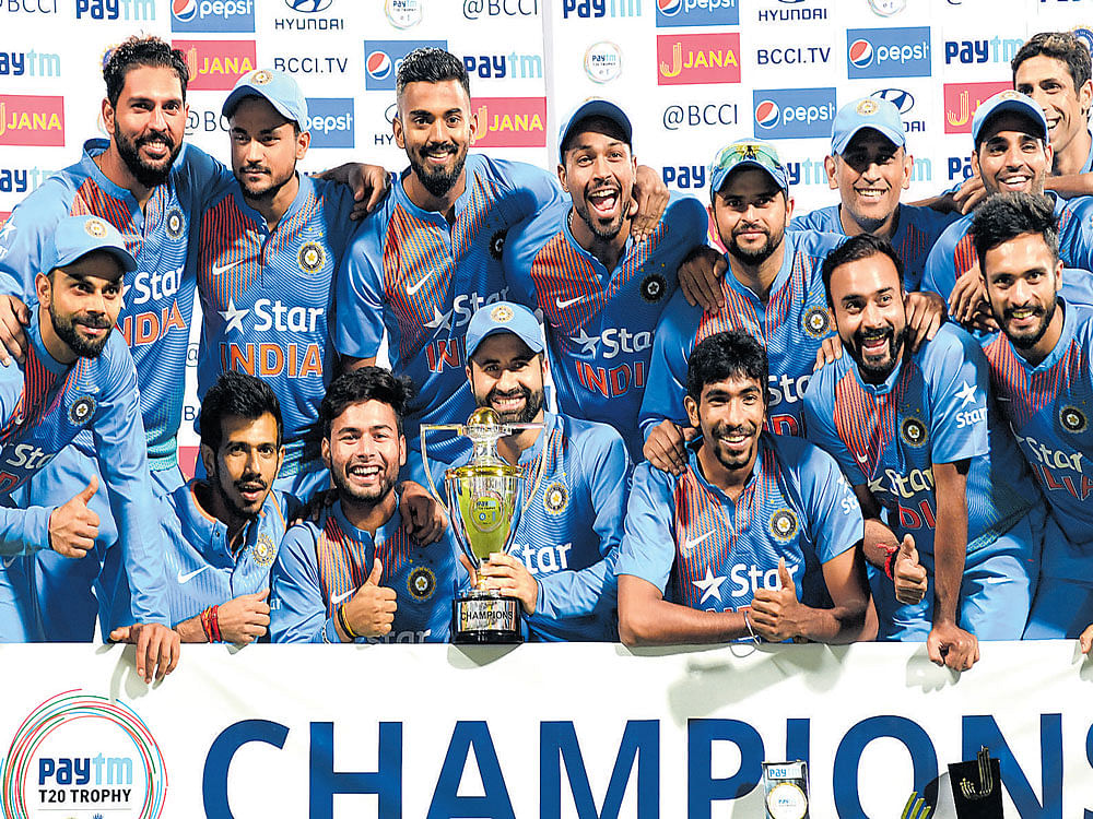 'triple treat: Indian players celebrate with the trophy after winning the T20I series against England in Bengaluru on Wednesday. dh photo/ srikanta sharma r