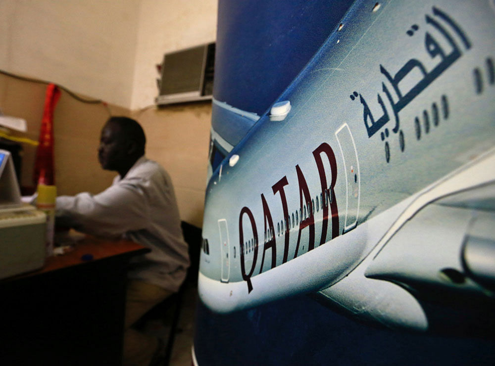 An image of a Qatar Airways plane is seen near an employee working at a travel agency in Khartoum, Sudan. Reuters Photo