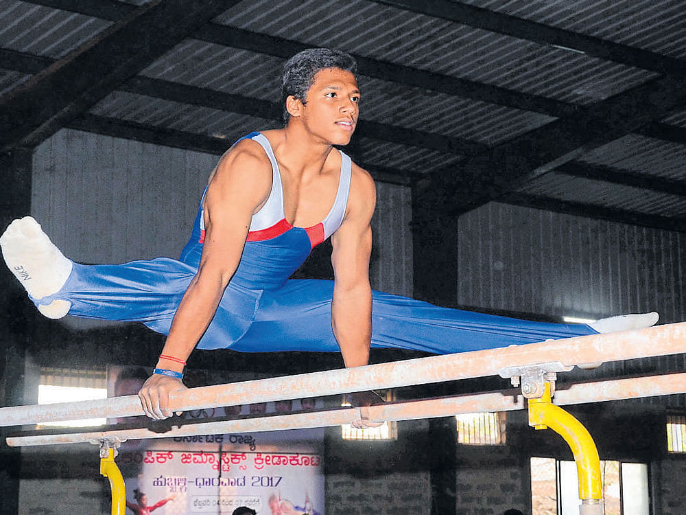 Super show: Bengaluru's Ujwal C Naidu en route to the individual title in the artistic gymnastics in the State Games in Dharwad on Monday. dh photo