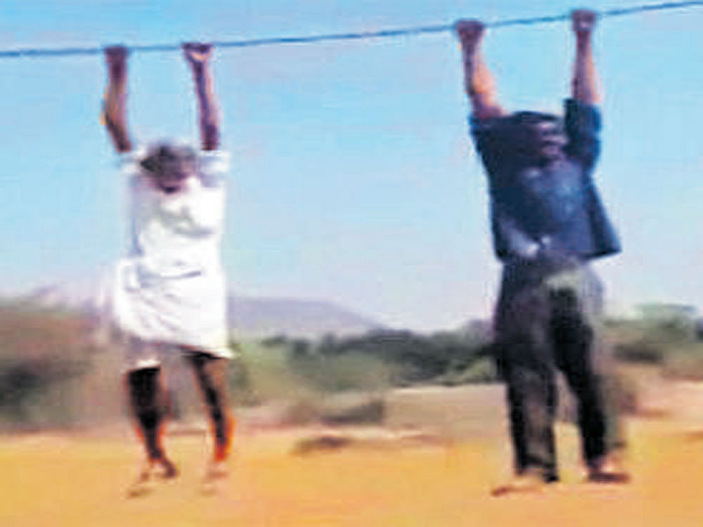 Subhan Saab and Nabi  Rasool hang on to power  cables in Anantapur district. DH PHOTO