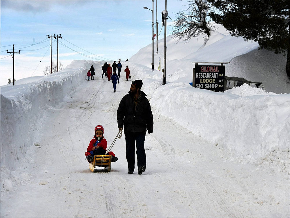 A girl enjoying a sledge ride after recent heavy snowfall at ski resort Gulmarg in North Kashmir on Wednesday. PTI Photo