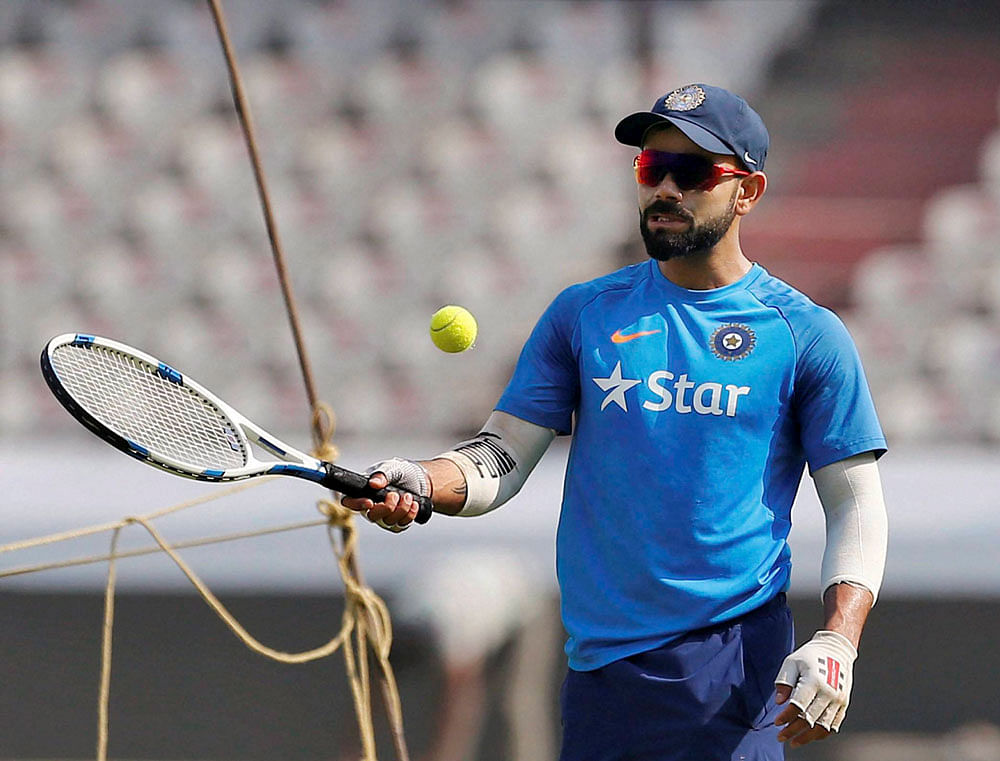 Tennis, anyone?: Virat Kohli tries his skills in another ball game on the eve of the one-off Test against Bangladesh. PTI