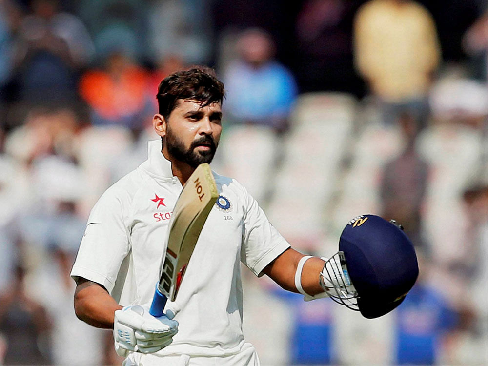 India's Murali Vijay raises his bat and helmet to celebrate scoring a century during the first day of the test match against Bangladesh in Hyderabad on Thursday. PTI Photo