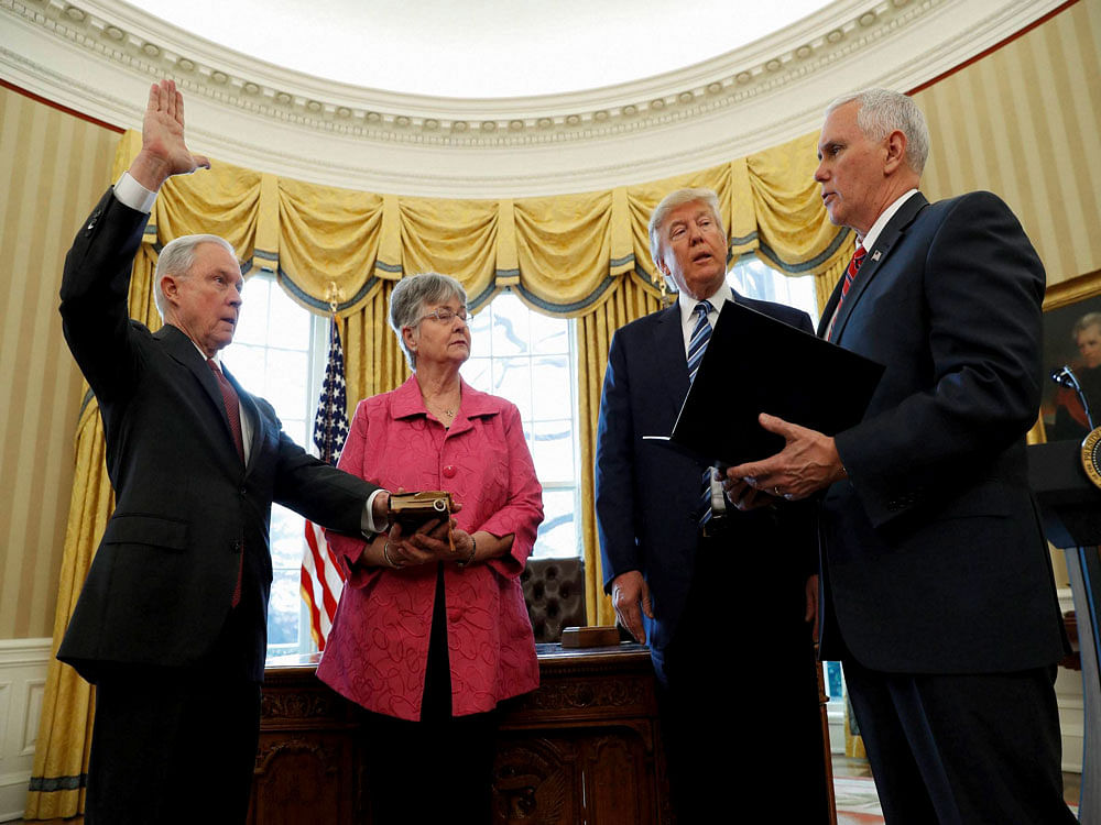 President Donald Trump watches as Vice President Mike Pence administers the oath of office to Attorney General Jeff Sessions, accompanied by his wife Mary, Thursday, Feb. 9, 2017, in the Oval Office of the White House in Washington. AP/PTI