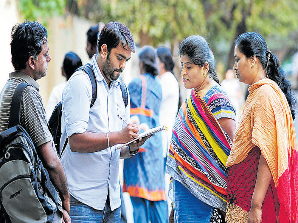 Volunteers collect signatures for the campaign against  cutting of trees on Jayamahal Road on Thursday. dh photo