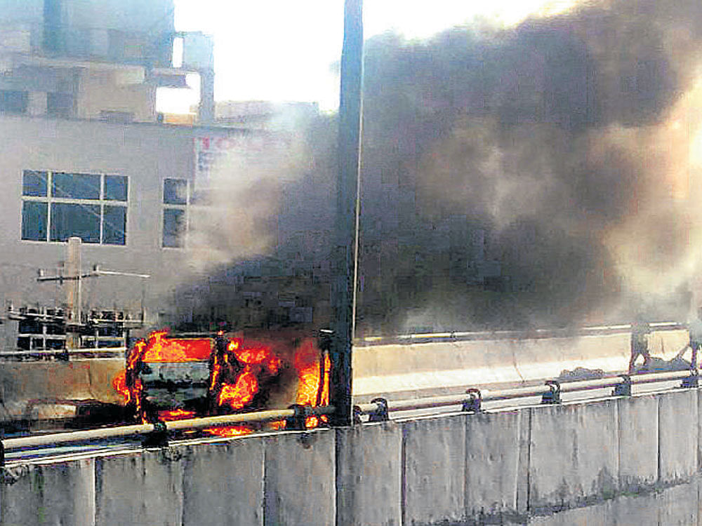 A car goes up in flames causing traffic jam on Marathahalli-Bellandur Road on Friday evening.