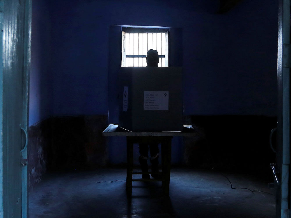 A man casts his vote inside a booth at a polling station during the state assembly election, in Hapur, in the central state of Uttar Pradesh, India, February 11, 2017. REUTERS Photo