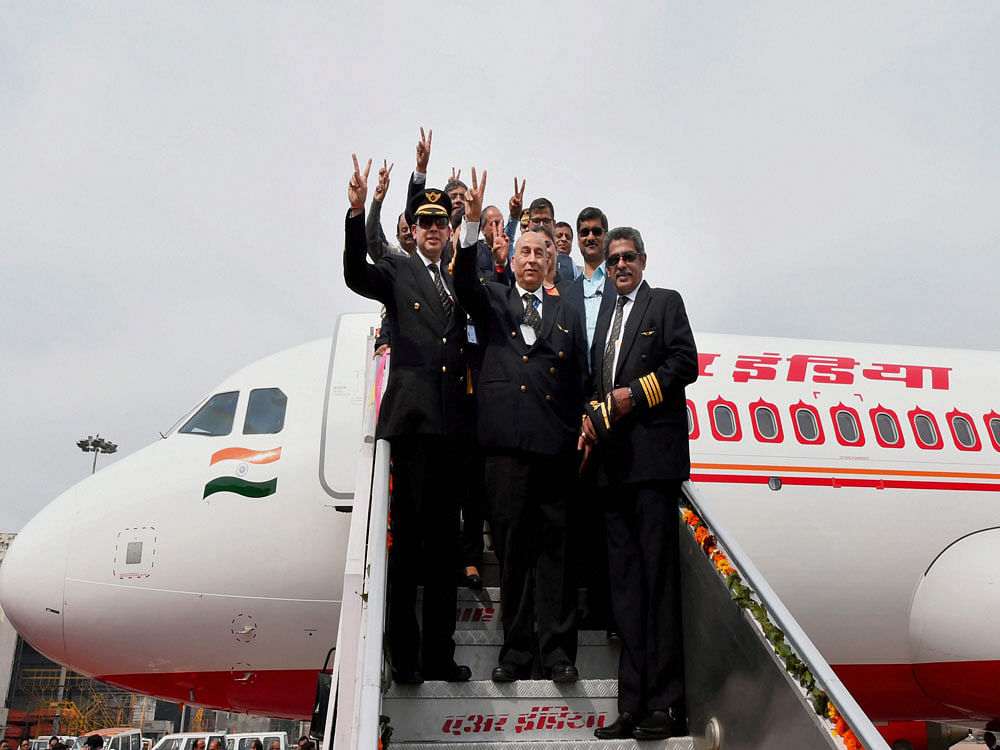 Officials of airbus India and Air India showing victory sign as first Airbus 320 neo plane arrives at Avionics Complex, Air India hanger IGI in New Delhi on Thursday. Air India inducted the first Airbus 320 neo plane, touted as fuel efficient, into its fleet and plans to take 13 more such aircraft on lease this year. PTI Photo