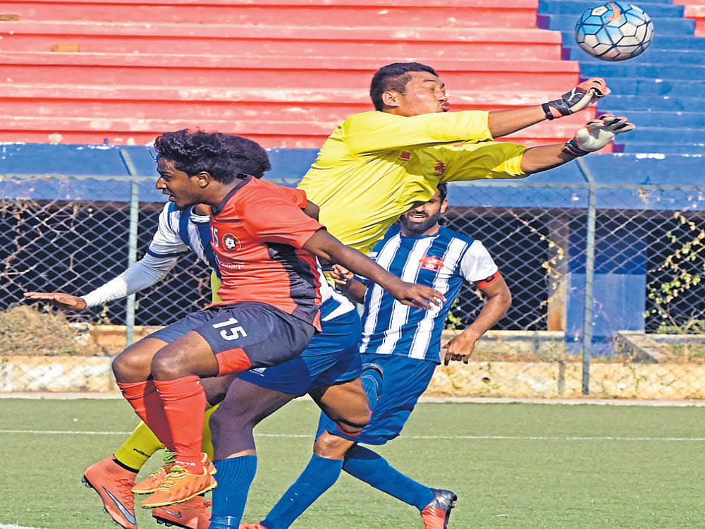 FINE EFFORT Fateh Hyderabad goalkeeper Kunzang Bhutia (centre) saves a strike from an Ozone FC player. DH PHOTO