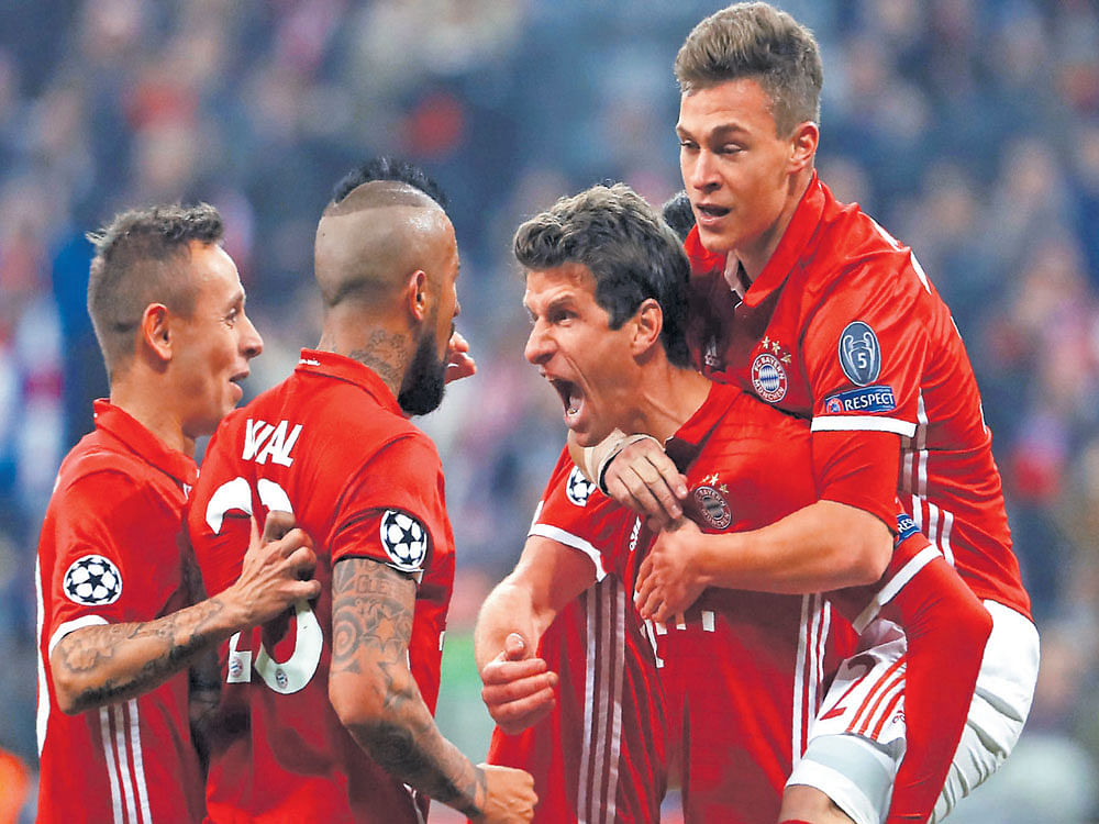 ECSTATIC: Bayern Munich's Thomas Mueller (centre) celebrates with team-mates after scoring against Arsenal in their Champions League last-16 tie in Munich on Wednesday. AFP