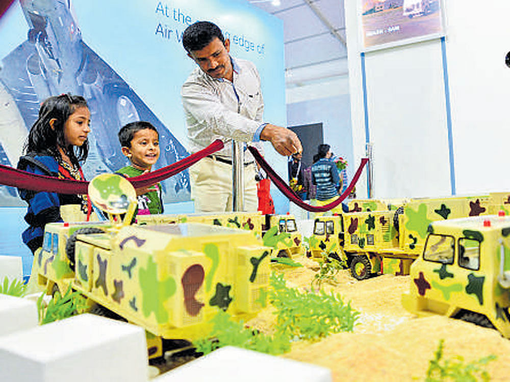 Children take a look at  models of military vehicles at a stall.