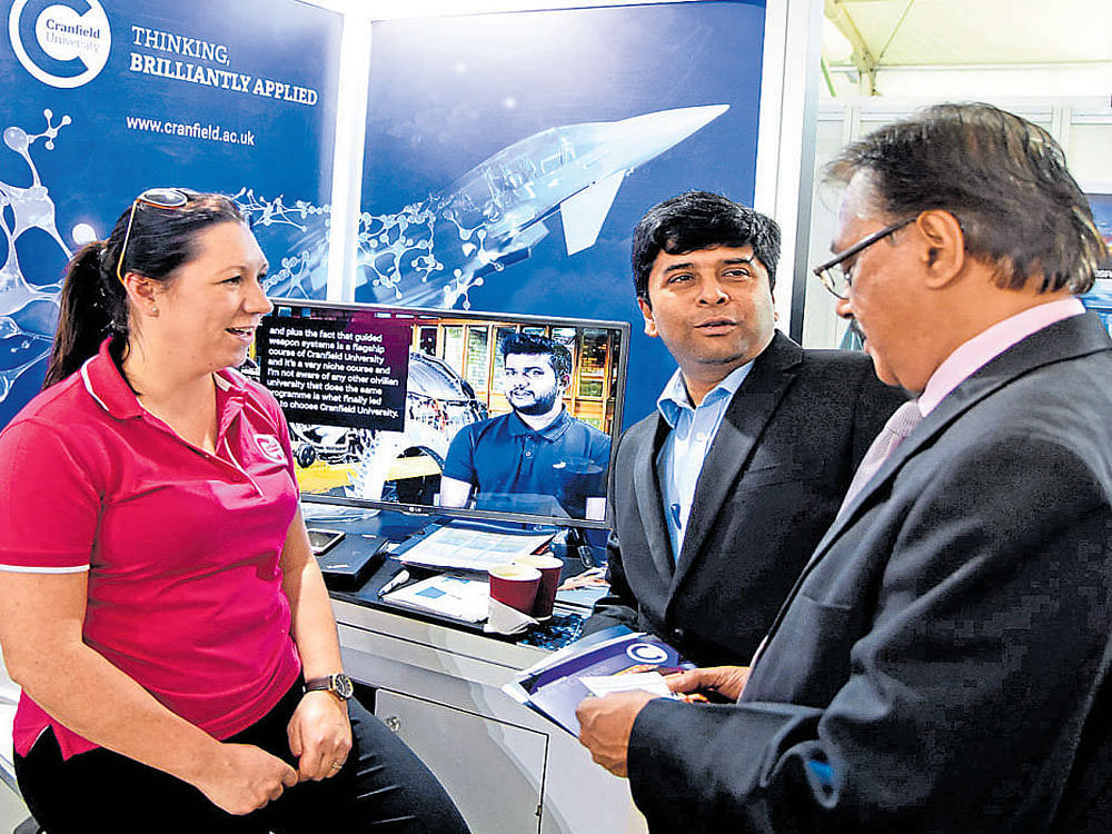 Representatives of UK-based Cranfield University interact with a visitor at their stall at Aero India show on Friday.