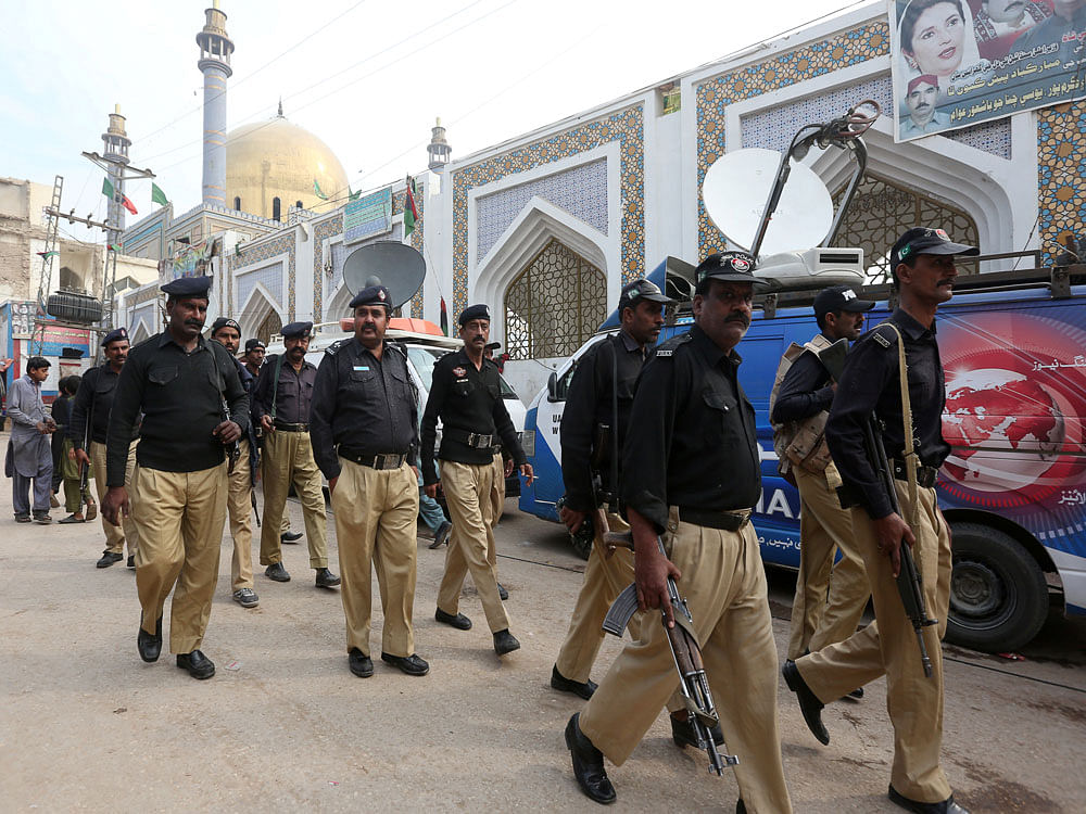 Policemen gather outside the tomb of Sufi saint Syed Usman Marwandi, also known as the Lal Shahbaz Qalandar shrine, after Thursday's suicide blast in Sehwan Sharif. Reuters photo