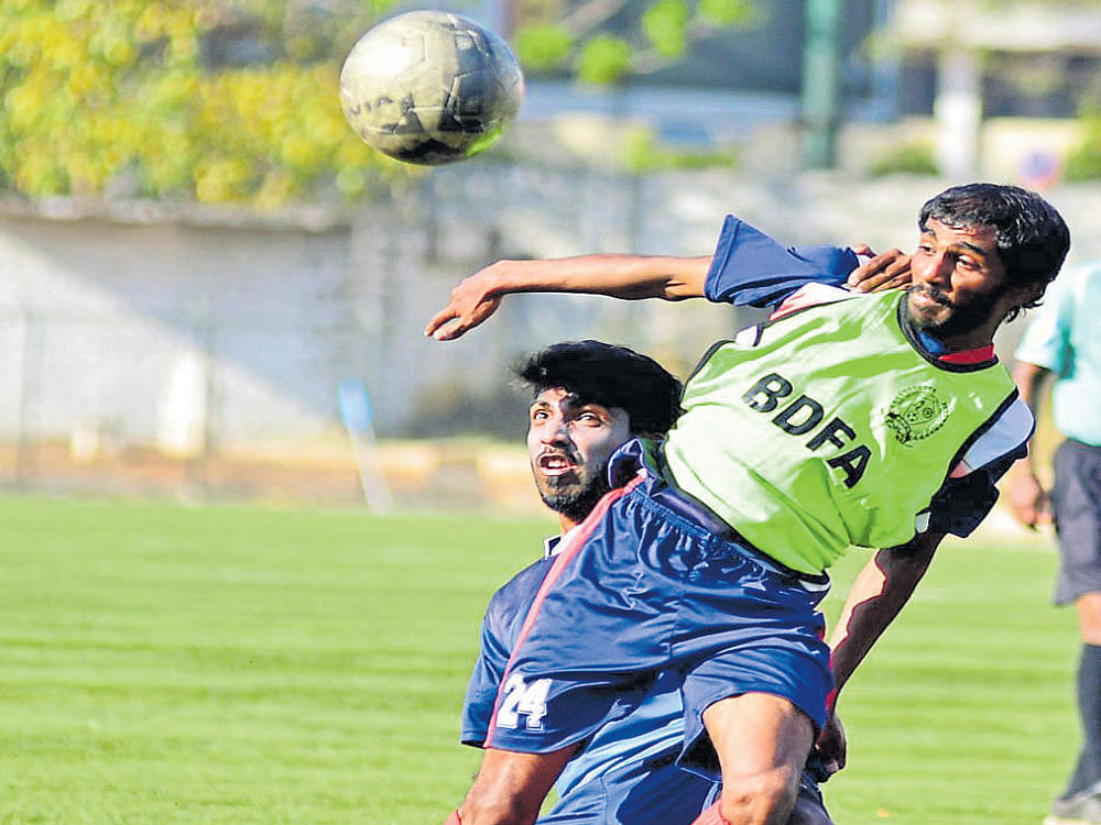 Intense AGORC's R Karthik (left) tussles for the ball with RWF's Shamnath during their tie on Saturday. DH photo