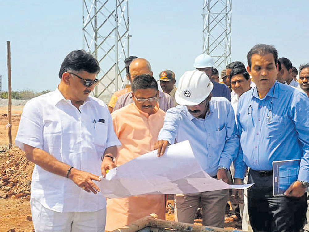 Energy Minister D K Shivakumar looks at the blue print of  solar park near Thirumani in Pavagad taluk in Tumakuru  district on Wednesday. DH photo