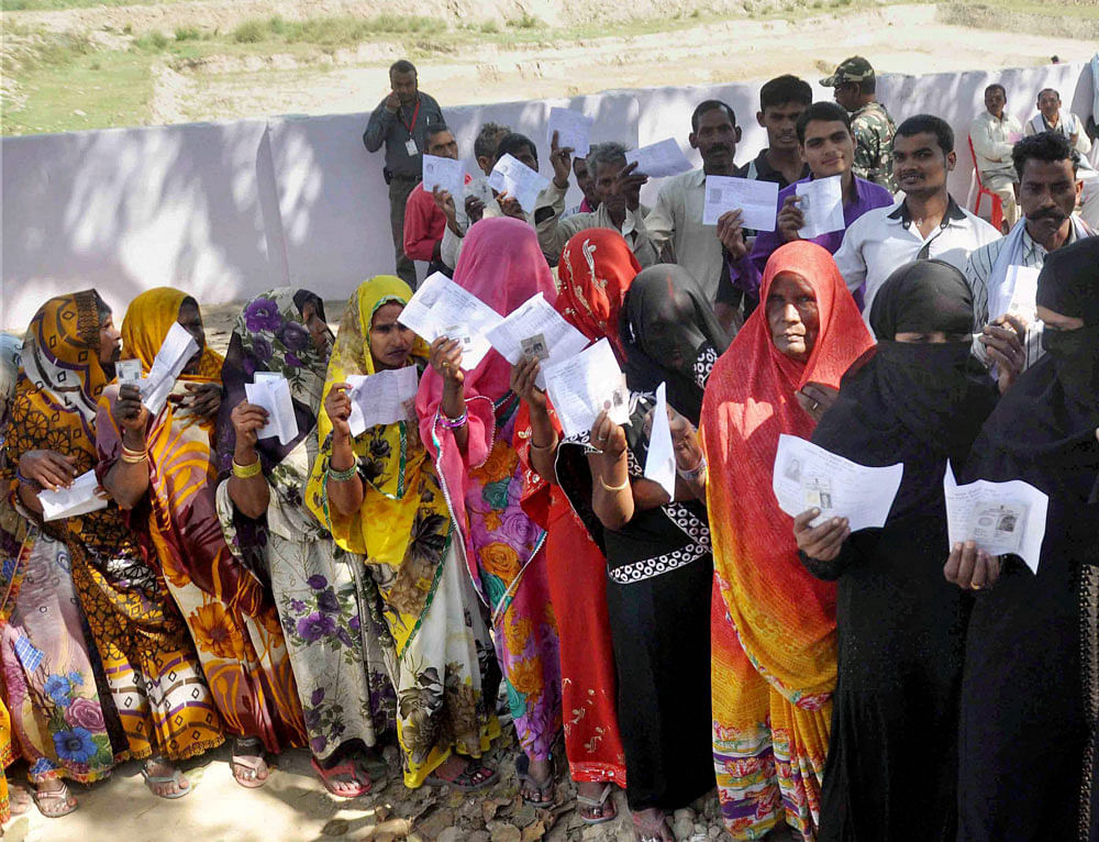 Voters stand in queues to cast their votes at a polling station during the fourth phase of assembly elections in Allahabad on Thursday. PTI Photo