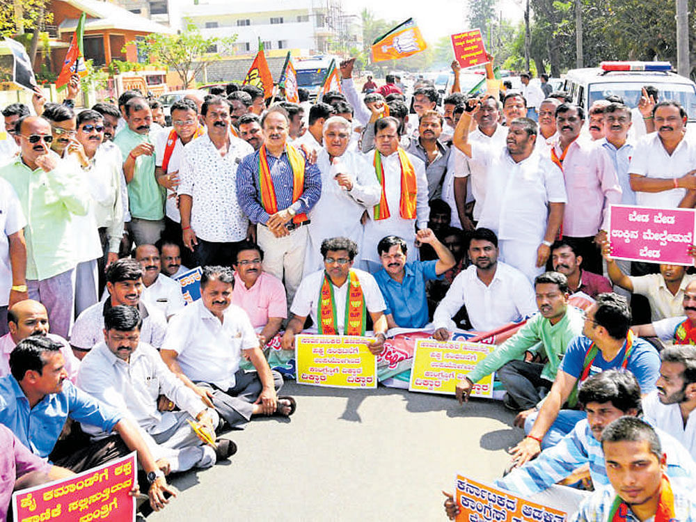 Members of BJP city unit stage a protest against Chief Minister Siddaramaiah and ministers for allegedly paying money to Congress party high command, near Siddaramaiah's residence in TK Layout, Mysuru on Saturday. DH photo
