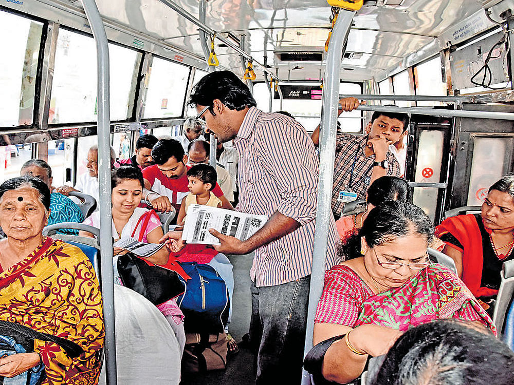 Members of Citizens for Bengaluru and Bus Prayaanikara Vedike distribute pamphlets of 'BusBhagyaBeku' campaign in a bus at Kempegowda Bus Station on Saturday. DH photo