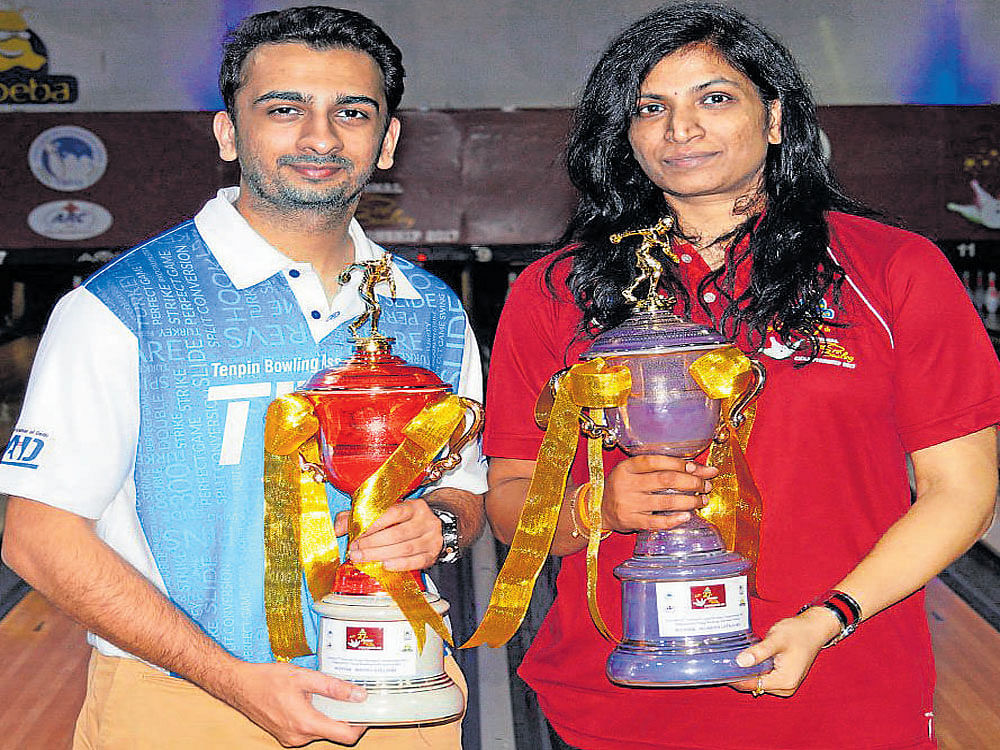 Champions Dhruv Sarda (left) and Sumathi N, winners in the men's and women's sections respectively, with their trophies on Saturday. DH PHOTO