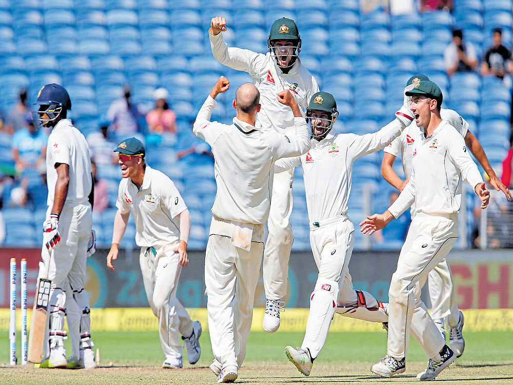 sensational start: Australian players celebrate after crushing India by 333 runs on the third day of the opening Test at Pune on Saturday. Reuters