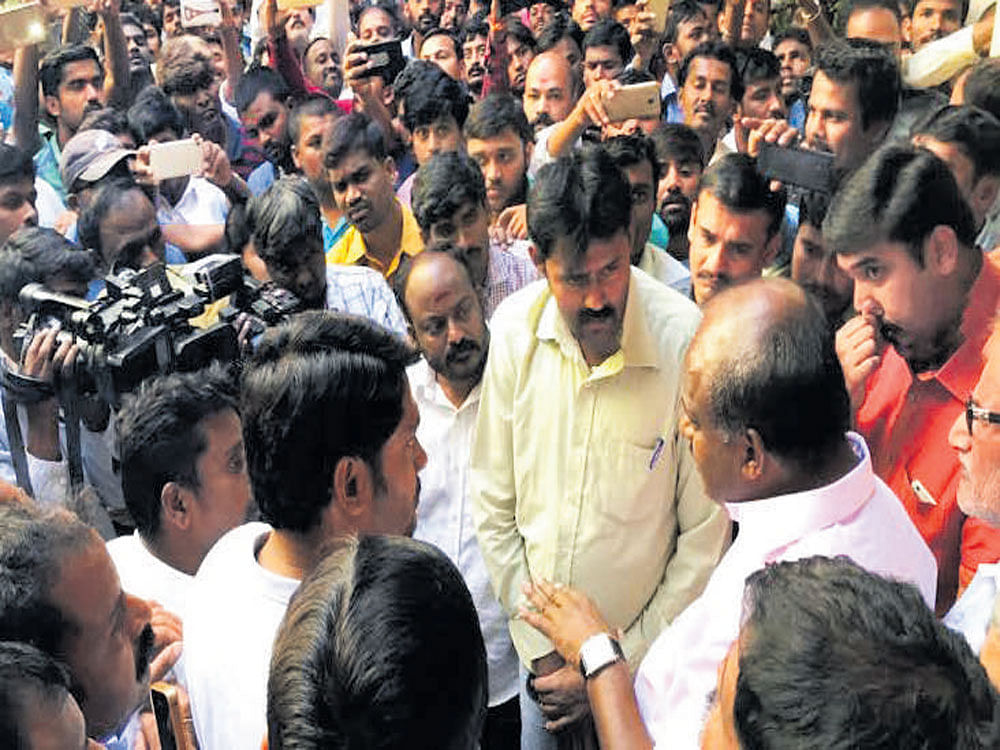 JD(S) leader H D Kumaraswamy speaks to Ola and Uber drivers on Tuesday. DH photo