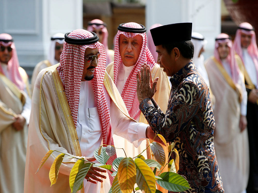 Indonesian President Joko Widodo gestures to King Salman of Saudi Arabia following a tree planting ceremony at the presidential palace in Jakarta. Reuters Photo.