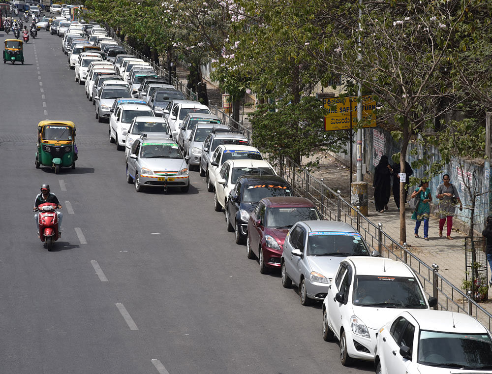 In protest mode: Cabs parked on the roadside as Ola and Uber cab drivers continue their protest at the Freedom Park on Thursday. DH Photo