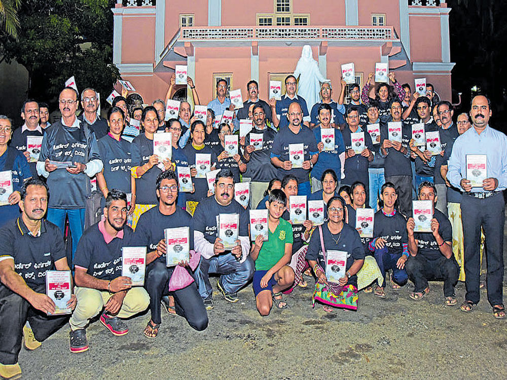 Parishioners from Holy Cross Church at Cordel display a  32-page booklet titled 'Cordelites Struggle for Justice' soon after its release in front of Bishop's House on Thursday evening. DH photo