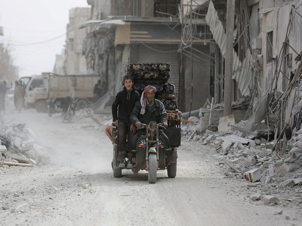 A Syrian family drives a vehicle in the northern Syrian town of al-Bab, Syria, February 28, 2017. REUTERS