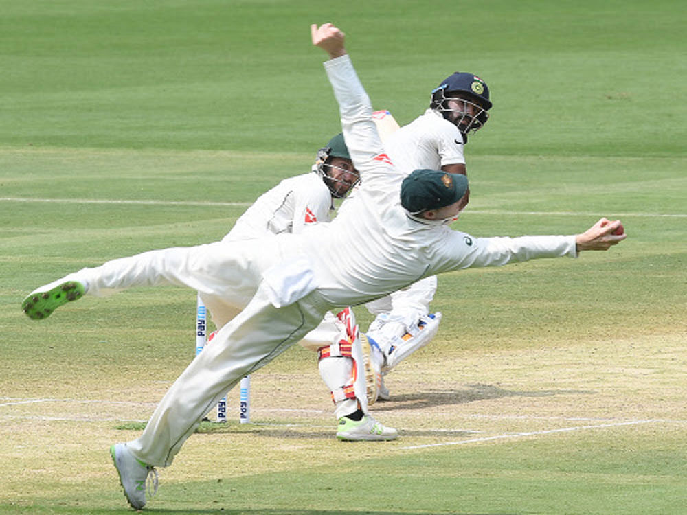 Australia's captain Smith taking a catch in slip of India's K L Rahul as Australia's wicket keeper M S Wade lookss in the 2nd test match of the 2nd innings on the 3rd days play at Chinnaswamy Stadium in Bengaluru on Monday. DH Photo.