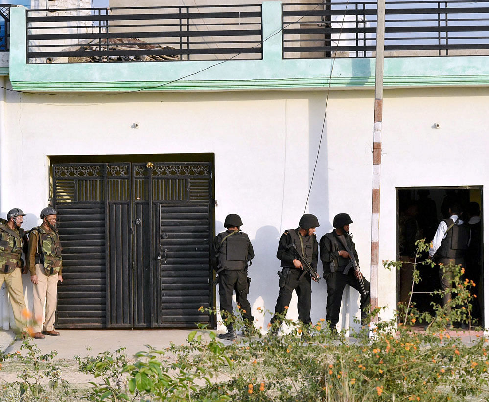 Uttar Pradesh Anti Terror Squad personnel take positions during their operation against a suspected terrorist holed up inside a building in the Thakurganj area of Lucknow on Tuesday evening. PTI Photo