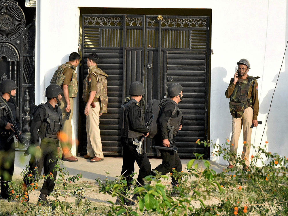 Uttar Pradesh Anti Terror Squad members take positions near a building where a suspected terrorist is holed up in the Thakurganj area of Lucknow on Tuesday. PTI Photo