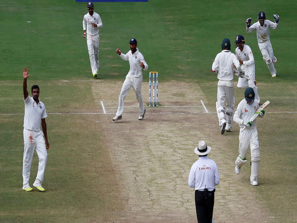 India v Australia - Second Test cricket match - M Chinnaswamy Stadium, Bengaluru, India - 07/03/17 - India's Ravichandran Ashwin (L) acknowledges the crowd as he celebrates the wicket of Australia's Peter Handscomb. REUTERS