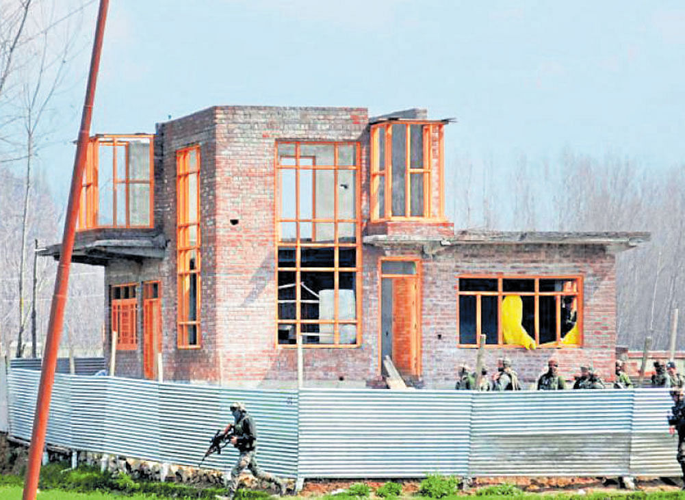 Army personnel survey the house where two LeT militants were hiding during an encounter at Padgampora village in  Pulwama district of south Kashmir on Thursday. PTI