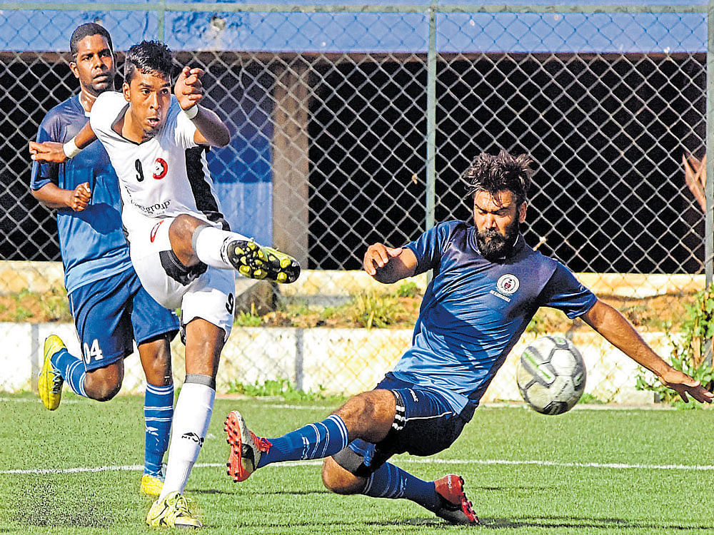 Unstoppable: Ozone FC's Anto Xavier (left) scores past  AGORC defence in the BDFA Super Division League at the Bangalore Football Stadium on Saturday. dh photo