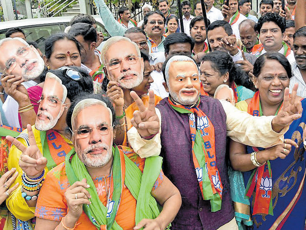 BJP workers celebrate the party's win in the Uttar Pradesh Assembly elections, in Bengaluru on Saturday.