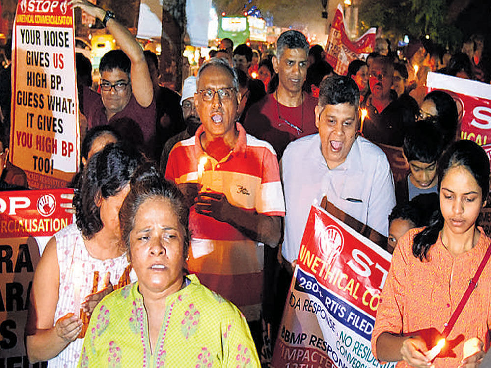 Indiranagar residents hold a candelight vigil against commercialisation of their neighbourhood on Saturday. DH Photo