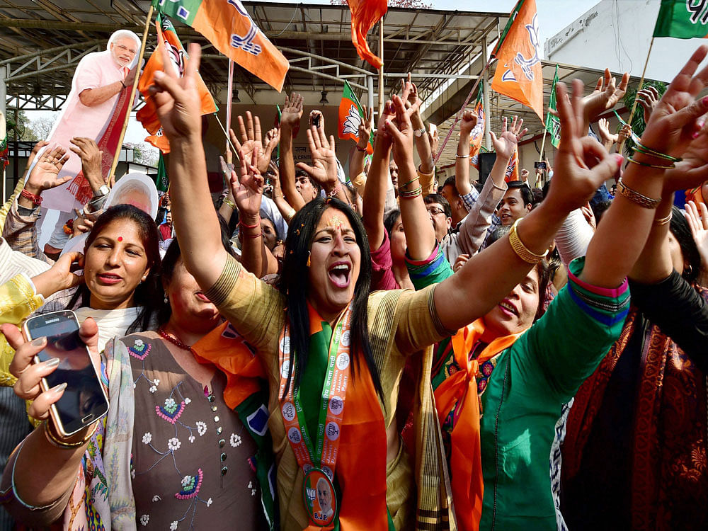 BJP workers dance as they celebrate the party's victory in the UP and Uttarakhand Assembly elections, at the party headquarters in New Delhi on Saturday. PTI Photo