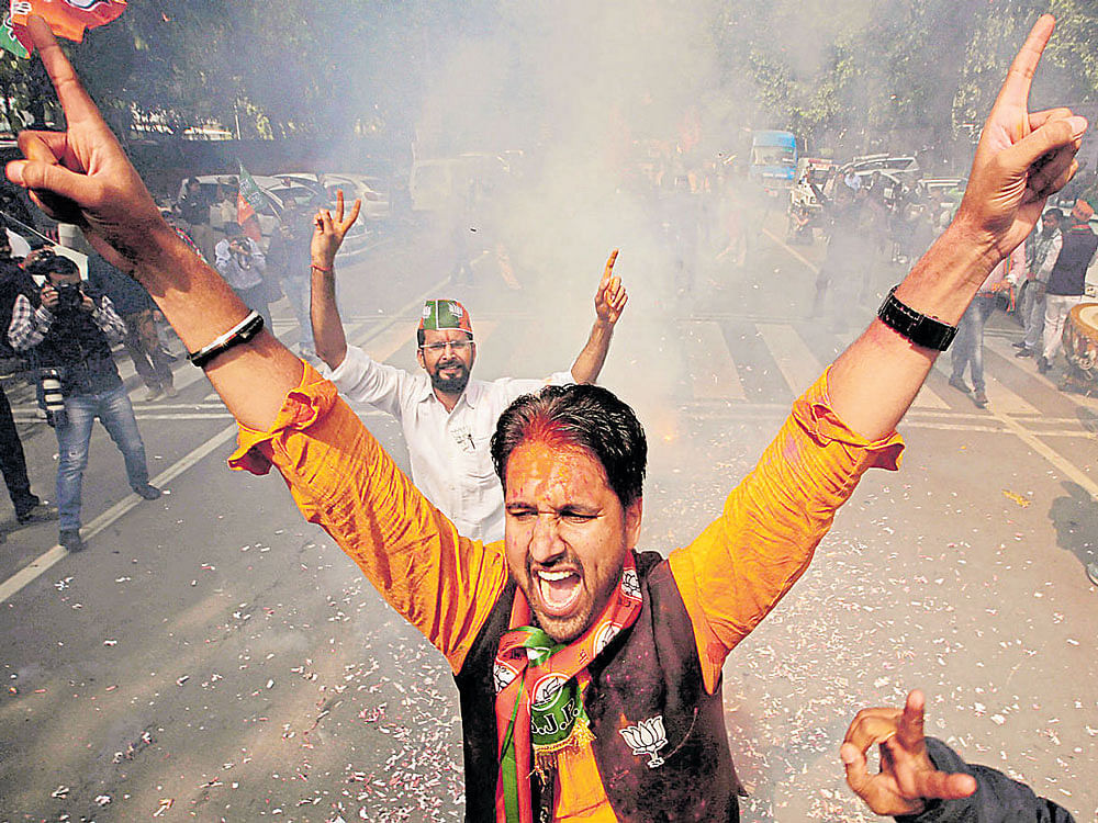 BJP&#8200;supporters celebrate outside the party headquarters in New Delhi on Saturday. Reuters