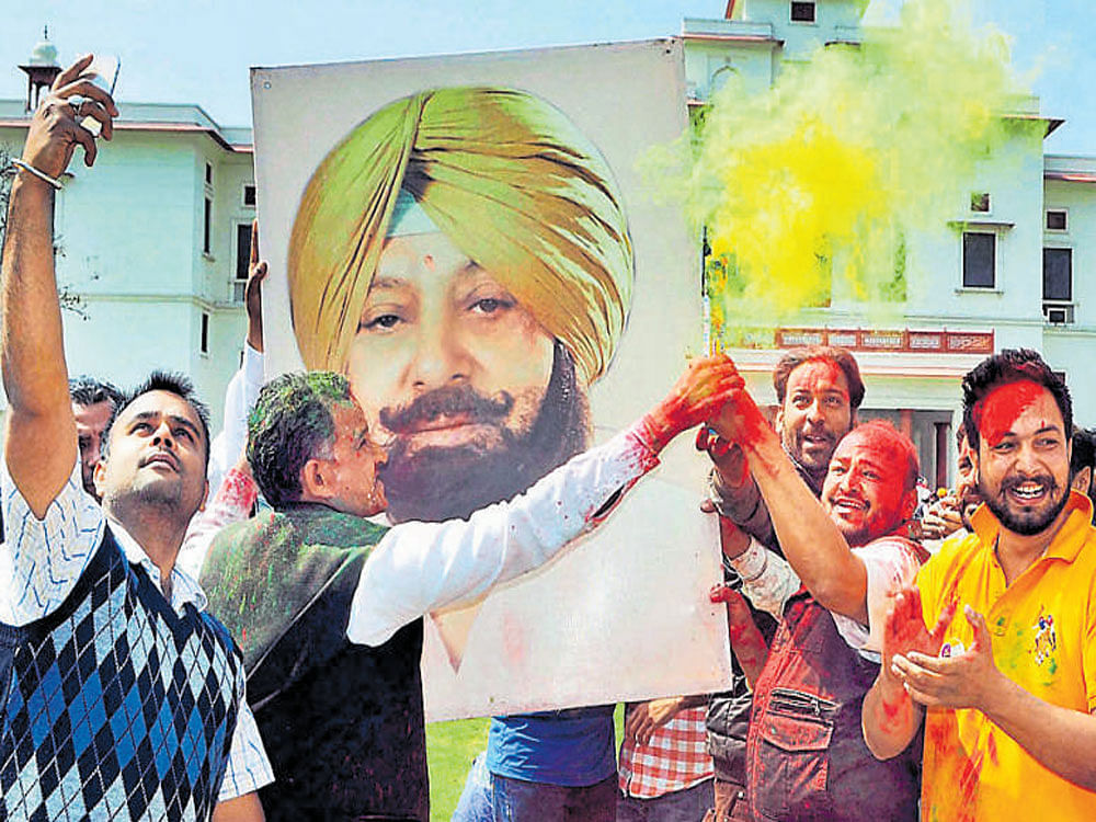 Congress workers celebrate party's best performance in the last two decades, outside Capt Amarinder Singh's house on Saturday. PTI
