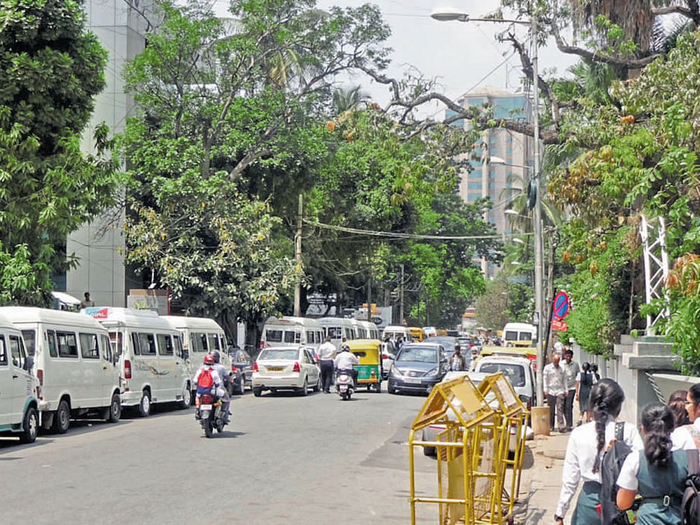 No way forward : Private school vans wrongly parked on Vittal Mallya Road. DH PHOTOS