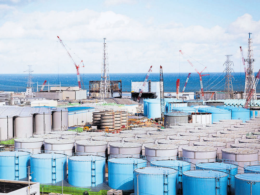 wasting away: Tanks for storing contaminated water and (inset) storage containers for rubble at the Fukushima Daiichi Nuclear Power Station. Japanese officials wrestle with what to do with the ever-growing pile of radioactive waste here, six years after the accident. nyt